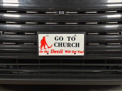 Close view of the license plate on the grille, showing the red devil figure and lettering